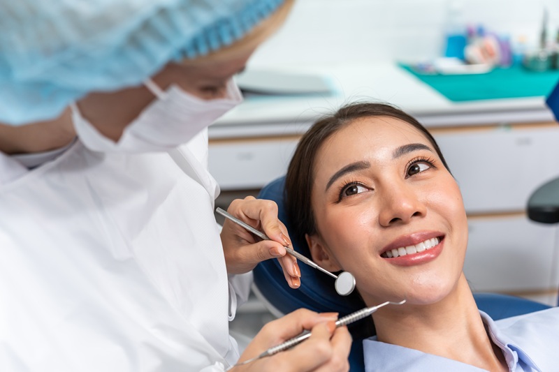 Caucasian dentist examine tooth for young girl at dental health clinic.