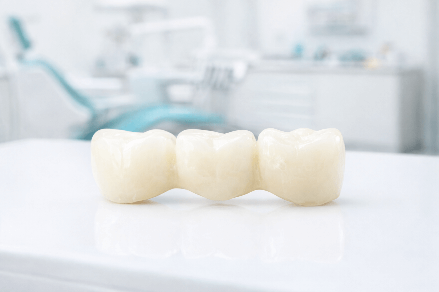 a sample of dental crowns and bridge on a table inside a dental clinic