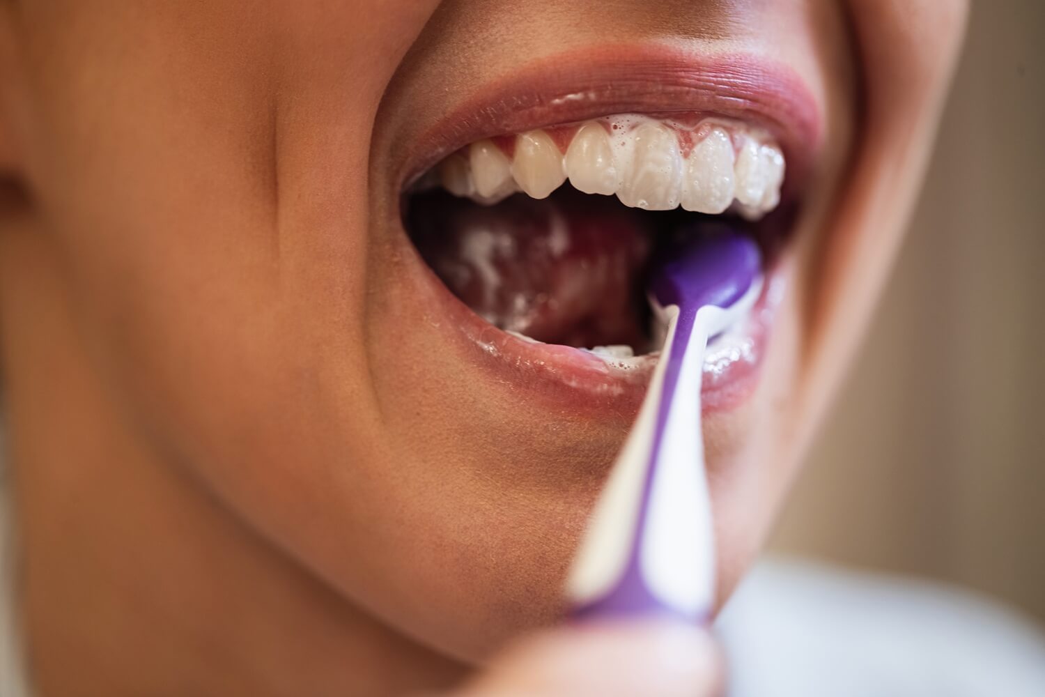 A woman brushing her veneer teeth