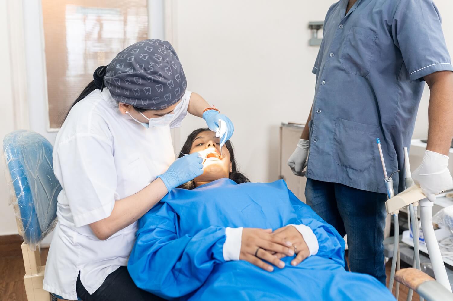 a woman having dental emergency service with 2 dentist